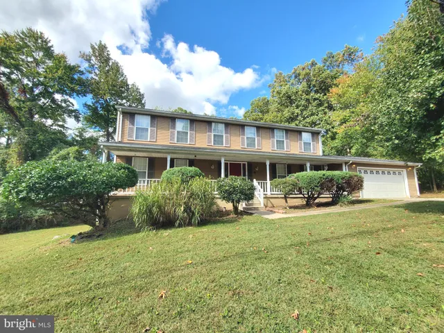 a view of a house with backyard sitting area and garden