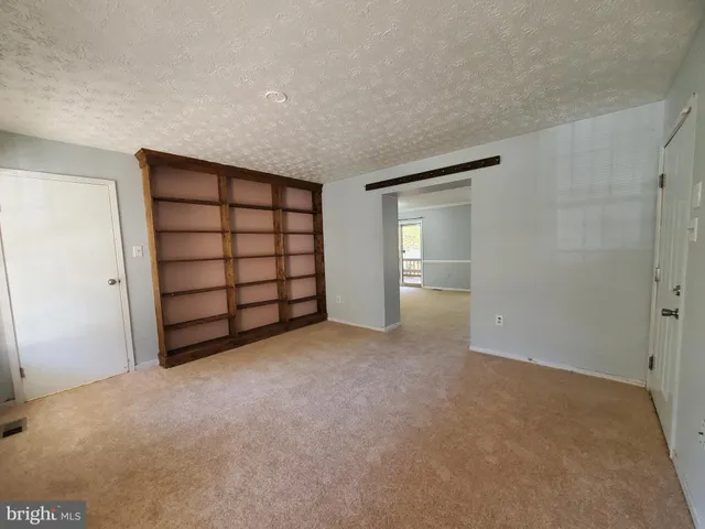 a view of empty room with closet and cabinet