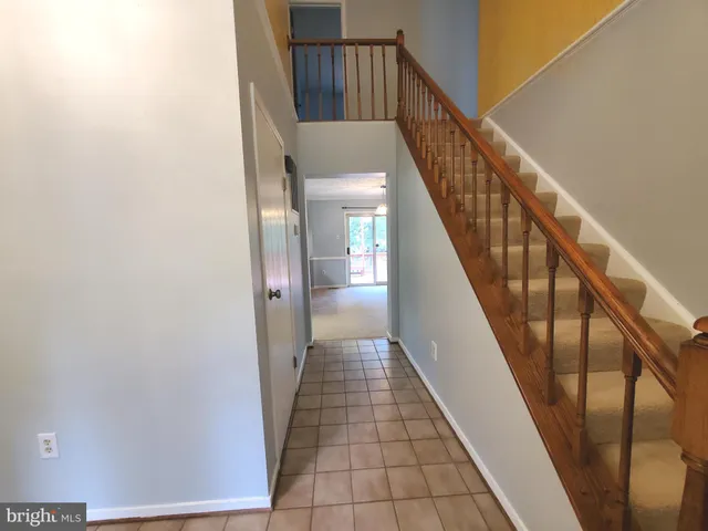 a view of staircase with railing and white walls