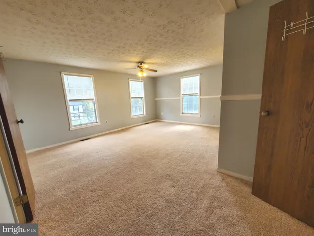 an empty room with windows and closet