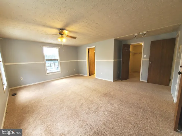 an empty room with windows and cabinet