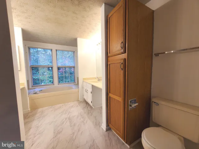 a bathroom with a granite countertop toilet a sink and bathtub