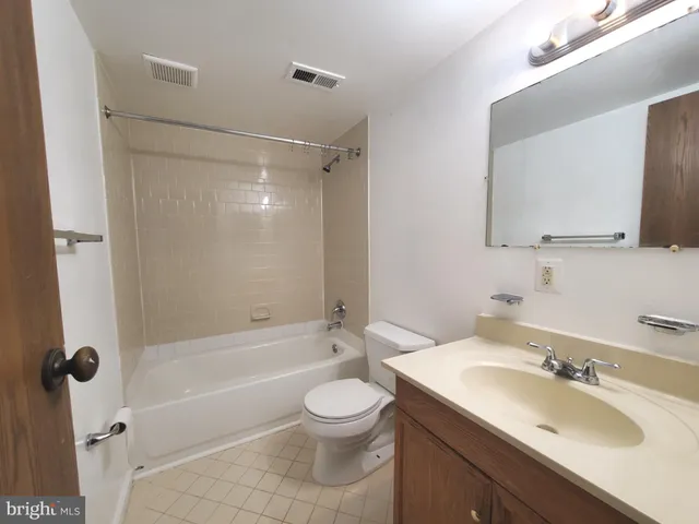 a bathroom with a granite countertop sink toilet a mirror and shower