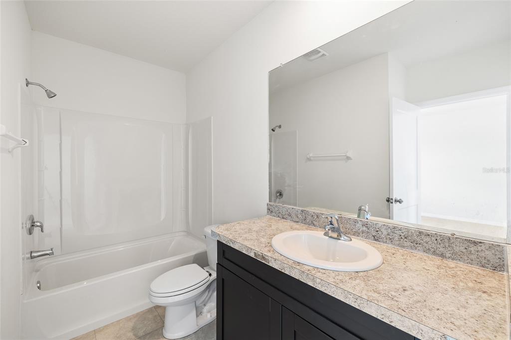 8502 Falling Blue Place Riverview, FL 33578 - Photo 17 of 32 a bathroom with a granite countertop sink toilet and shower