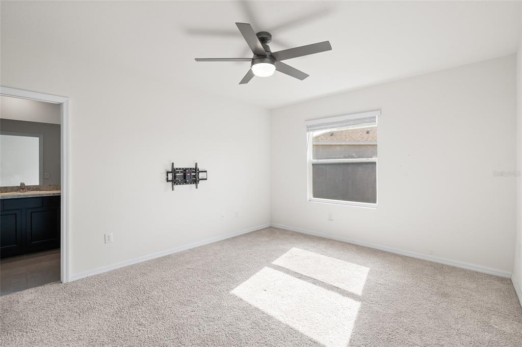 8502 Falling Blue Place Riverview, FL 33578 - Photo 22 of 32 an empty room with a window and a ceiling fan