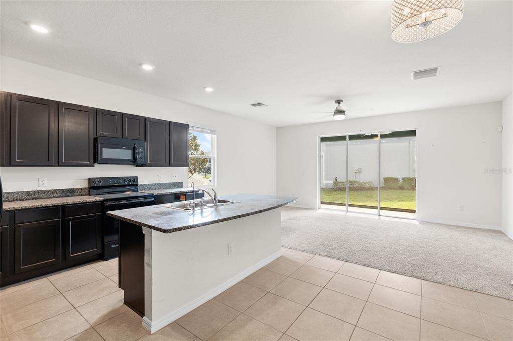 8502 Falling Blue Place Riverview, FL 33578 - Photo 5 of 32 a kitchen with kitchen island granite countertop a sink counter top space appliances and cabinets