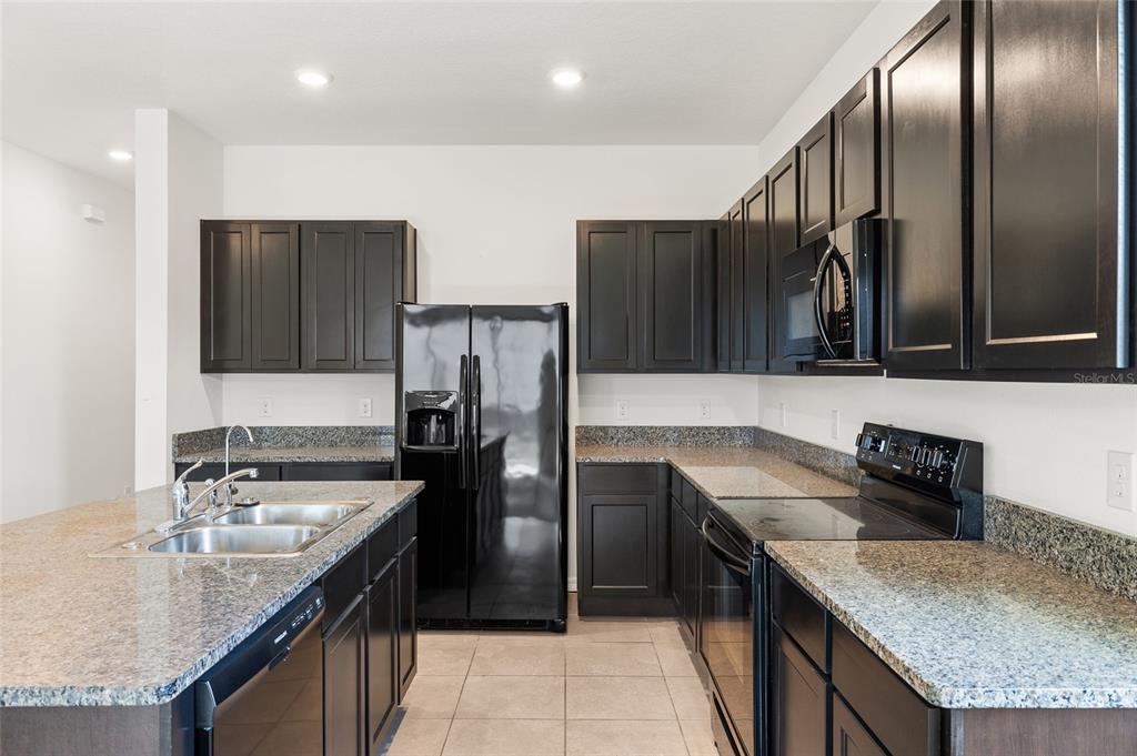 8502 Falling Blue Place Riverview, FL 33578 - Photo 7 of 32 a kitchen with stainless steel appliances granite countertop a sink stove and refrigerator