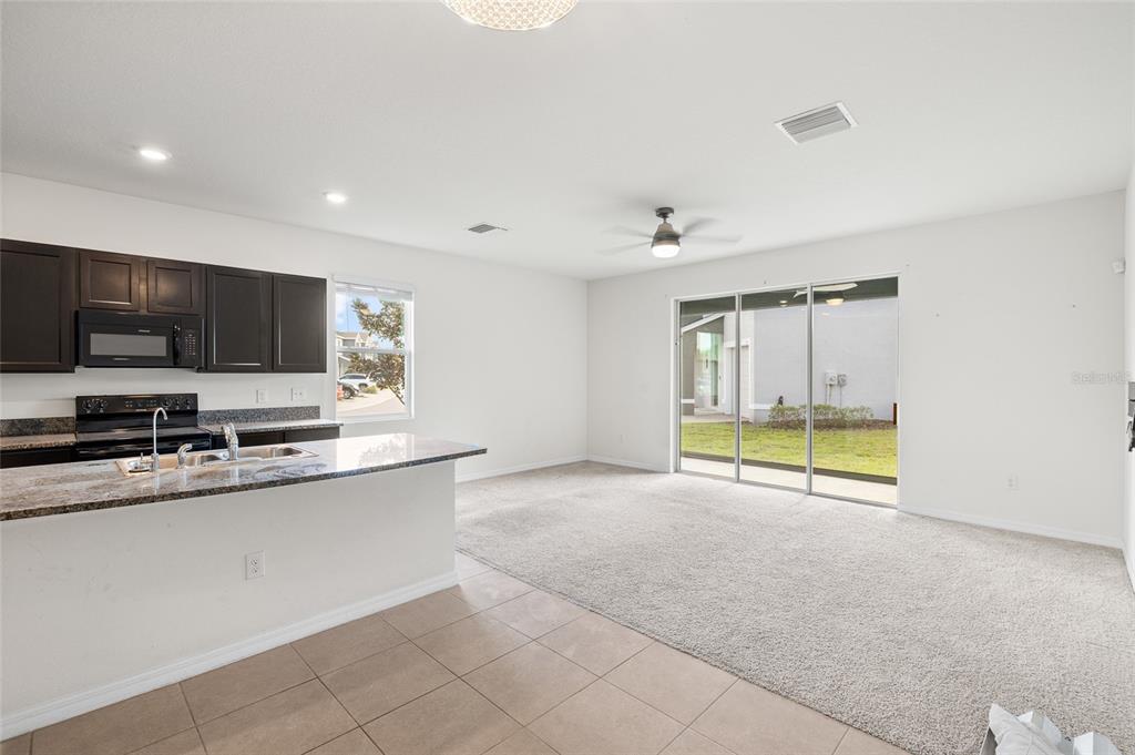 8502 Falling Blue Place Riverview, FL 33578 - Photo 10 of 32 a view of an empty room with a window and a kitchen