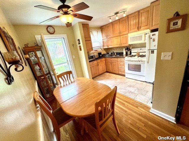 a kitchen with stainless steel appliances granite countertop a sink a stove a refrigerator with a dining table and chairs