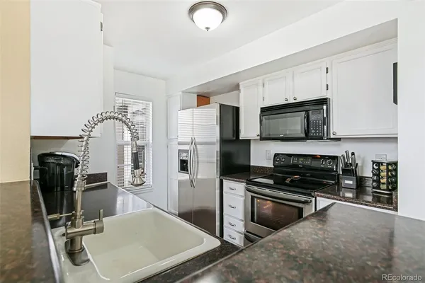 a kitchen with a refrigerator a stove and a sink