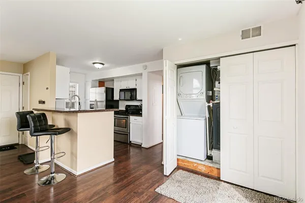a kitchen with a refrigerator and white cabinets