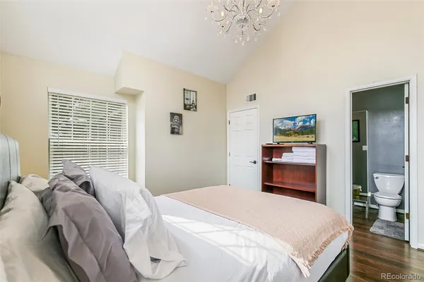 a bedroom with a bed and a chandelier