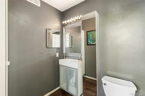 a bathroom with a toilet sink and mirror