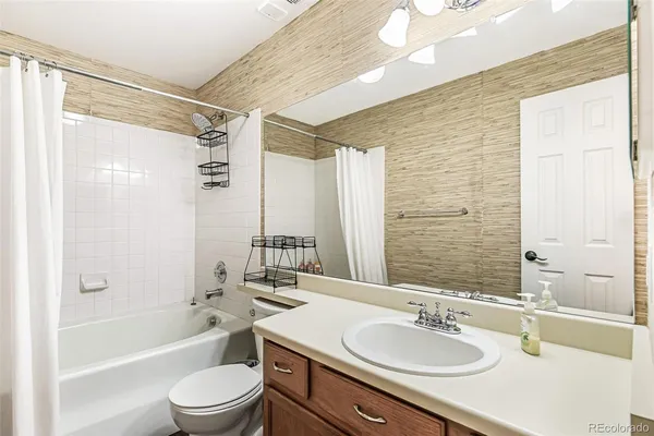 a bathroom with a sink granite tub toilet and shower