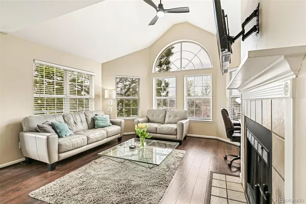 a living room with furniture a fireplace and a large window