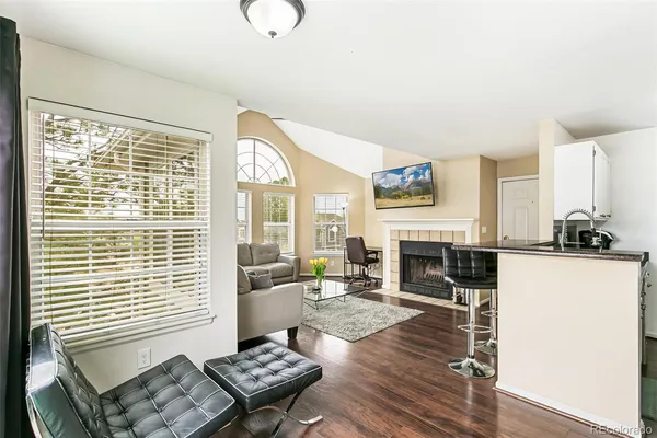 a living room with furniture a fireplace and a large window