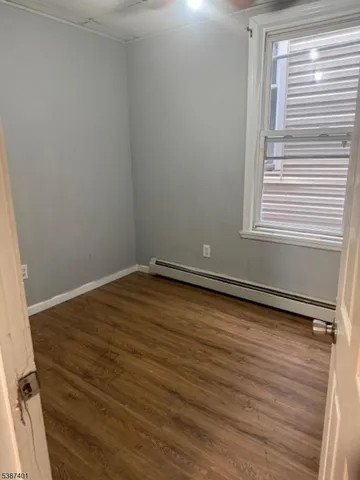 a view of a room with wooden floor and a window