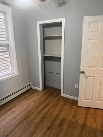 a view of an empty room with closet and a window