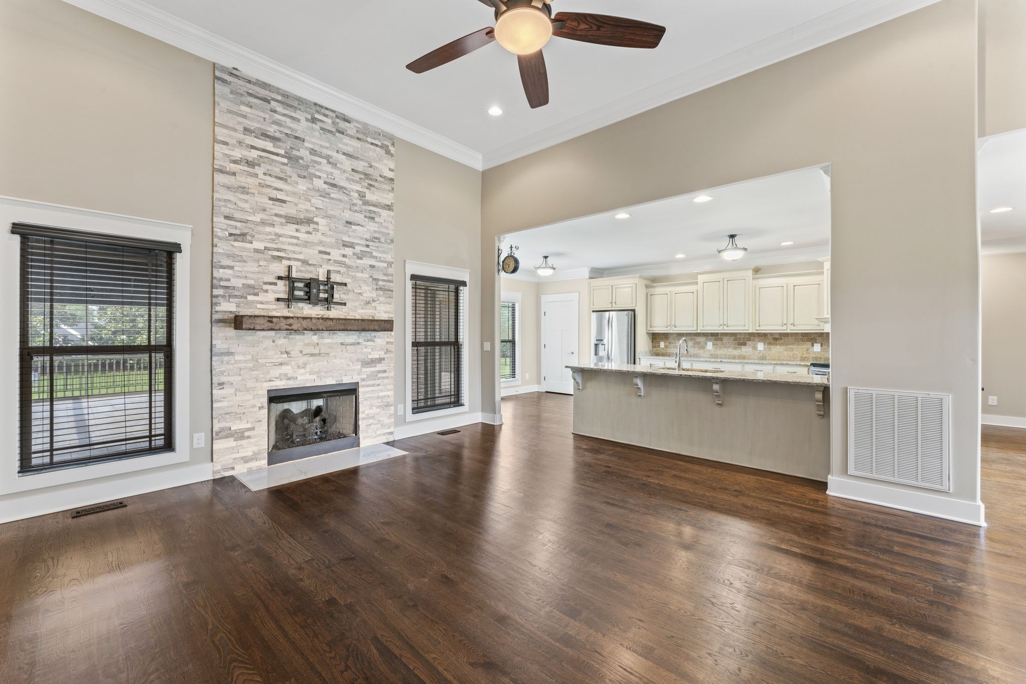 523 Urlacher Drive Murfreesboro, TN 37129 - Photo 10 of 45 an empty room with wooden floor a kitchen view and a fireplace