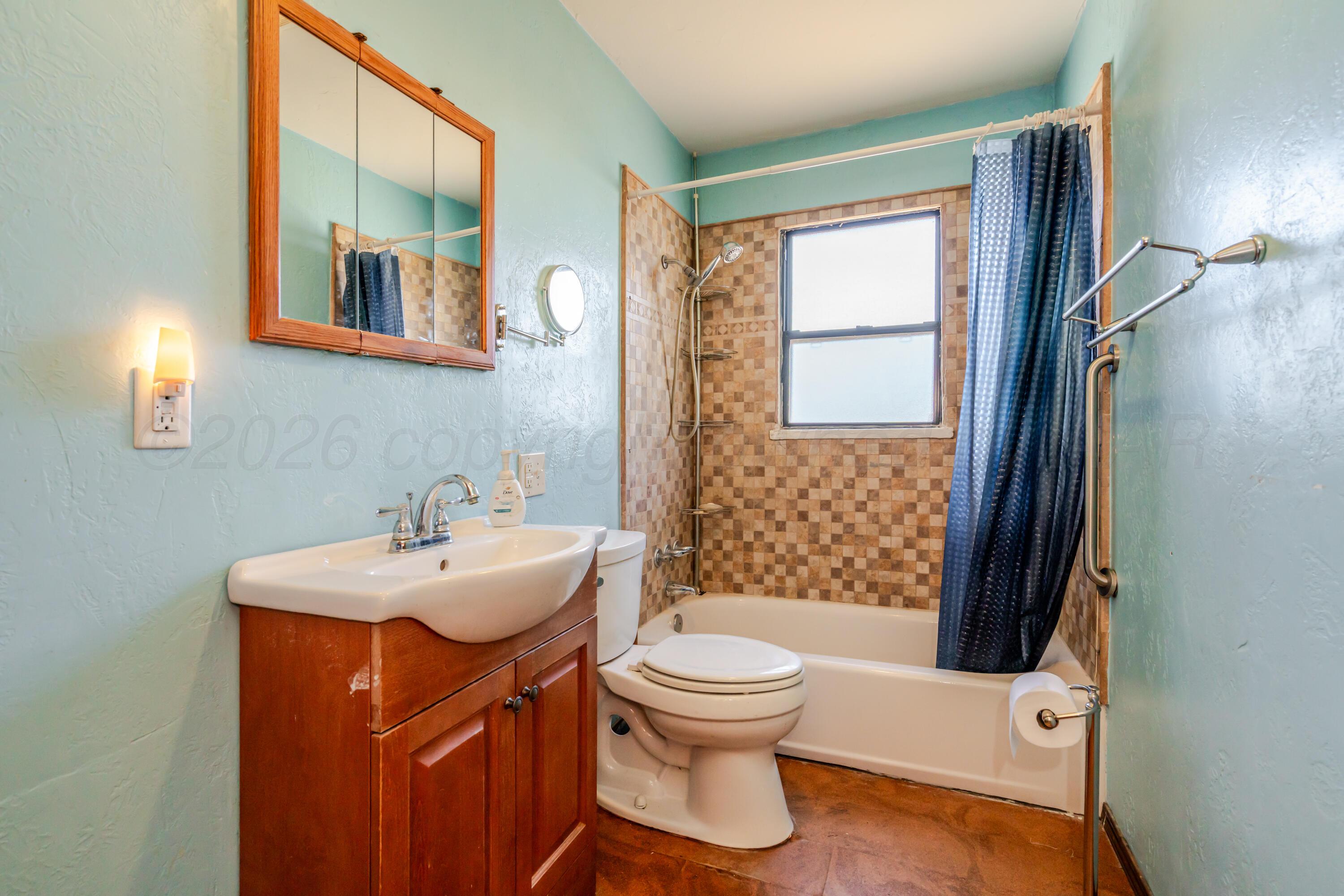 2805 Palm Street Amarillo, TX 79107 - Photo 13 of 17 a bathroom with a sink a toilet and shower