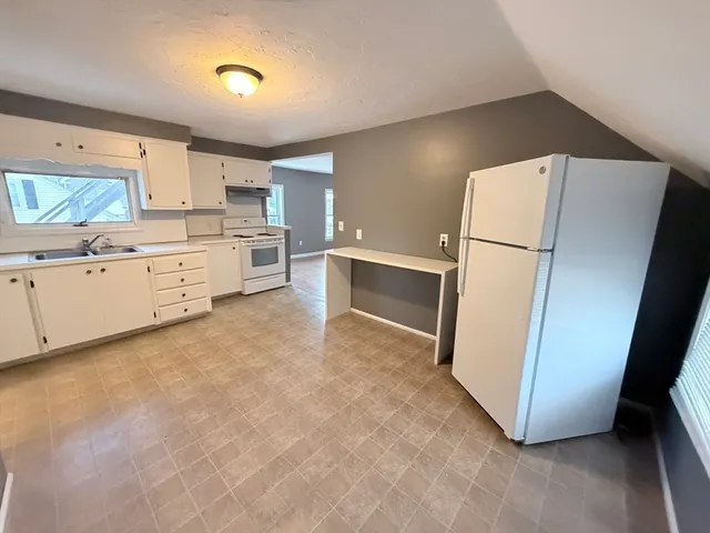 a kitchen with sink refrigerator and cabinets