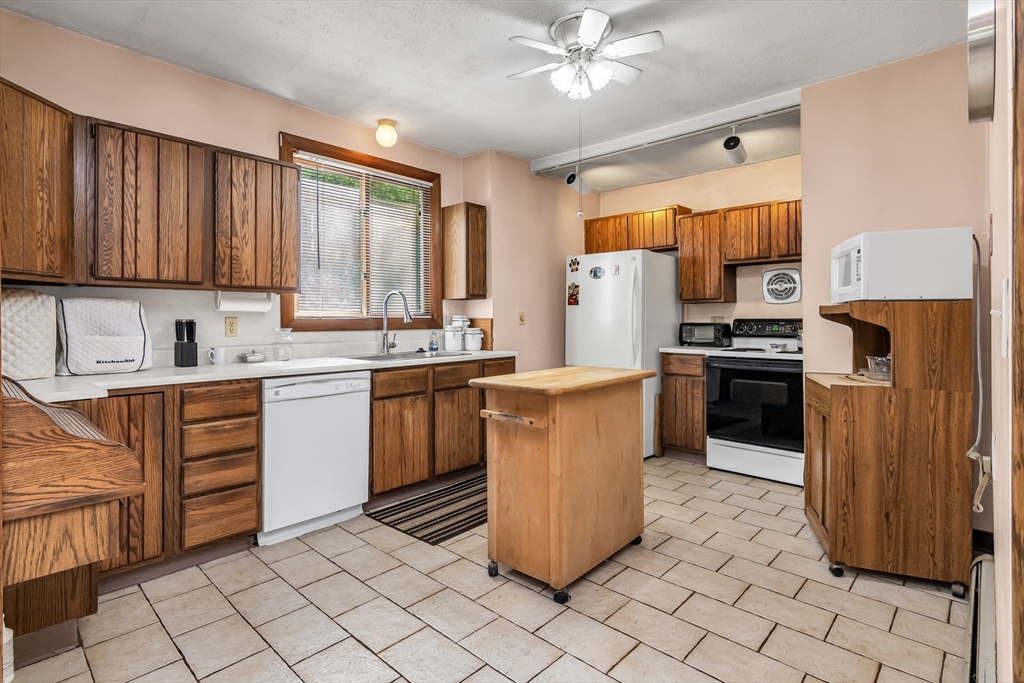 136 Vane Street Revere, MA 02151 - Photo 8 of 30 a kitchen with stainless steel appliances granite countertop a stove a sink dishwasher and a refrigerator