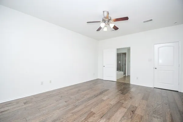 a view of an empty room with wooden floor