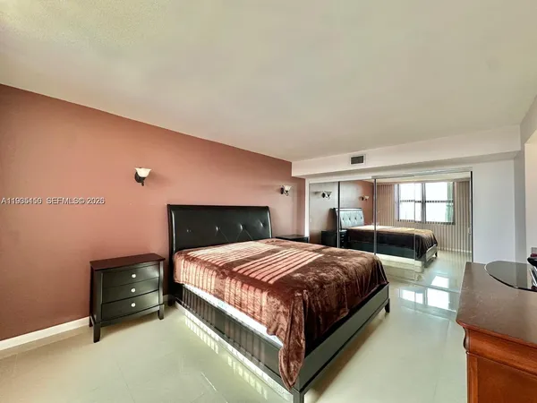a bedroom with a bed and large windows