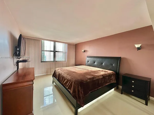 a bedroom with a bed and a dresser with mirror