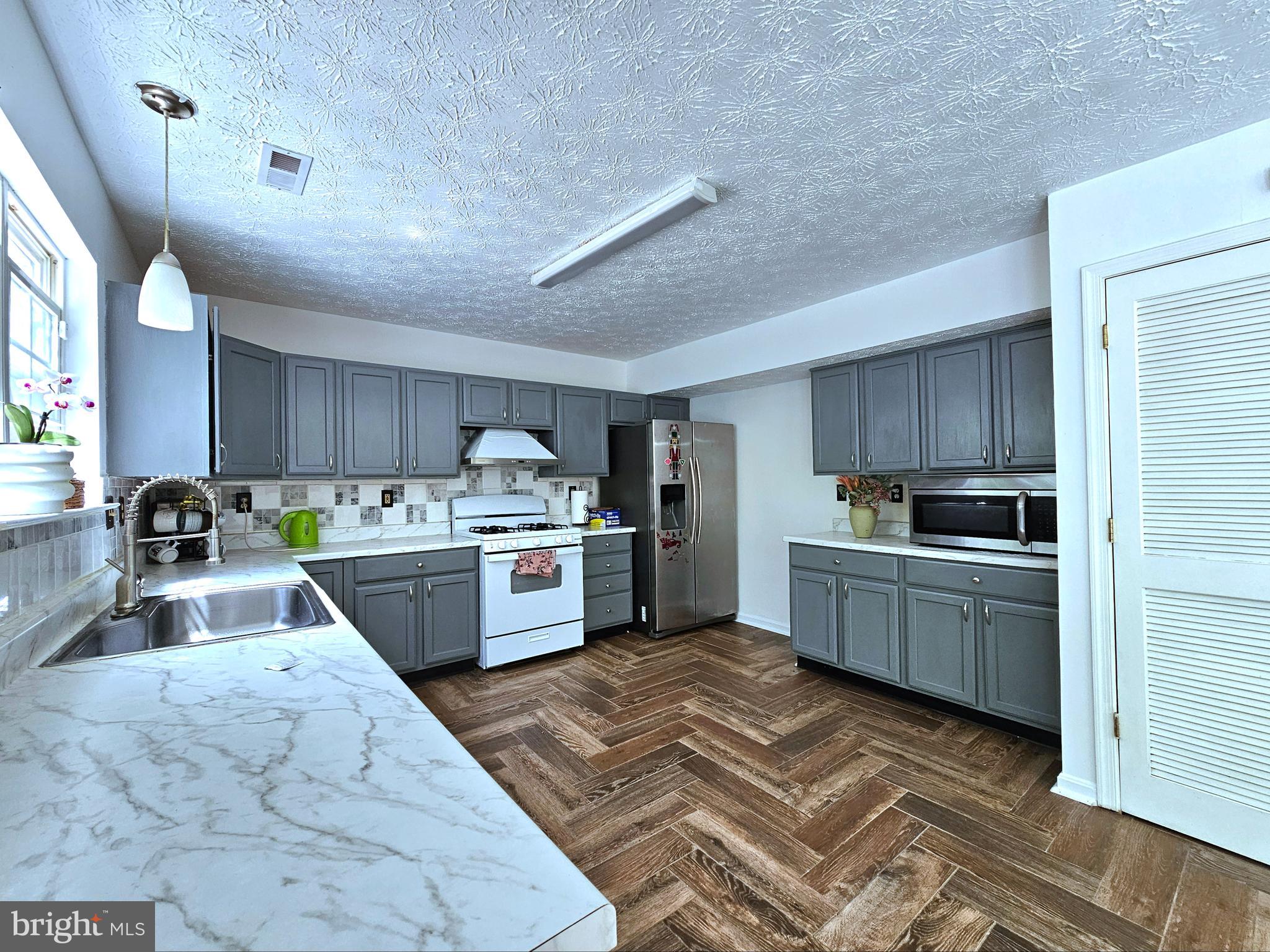 2506 Indians Lair Edgewood, MD 21040 - Photo 16 of 51 a kitchen with a stove sink cabinets and wooden floor