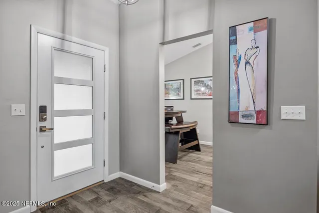 a view of a bedroom with a painting on the wall