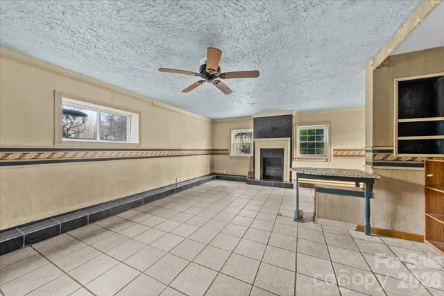 a view of a livingroom with furniture a ceiling fan and window