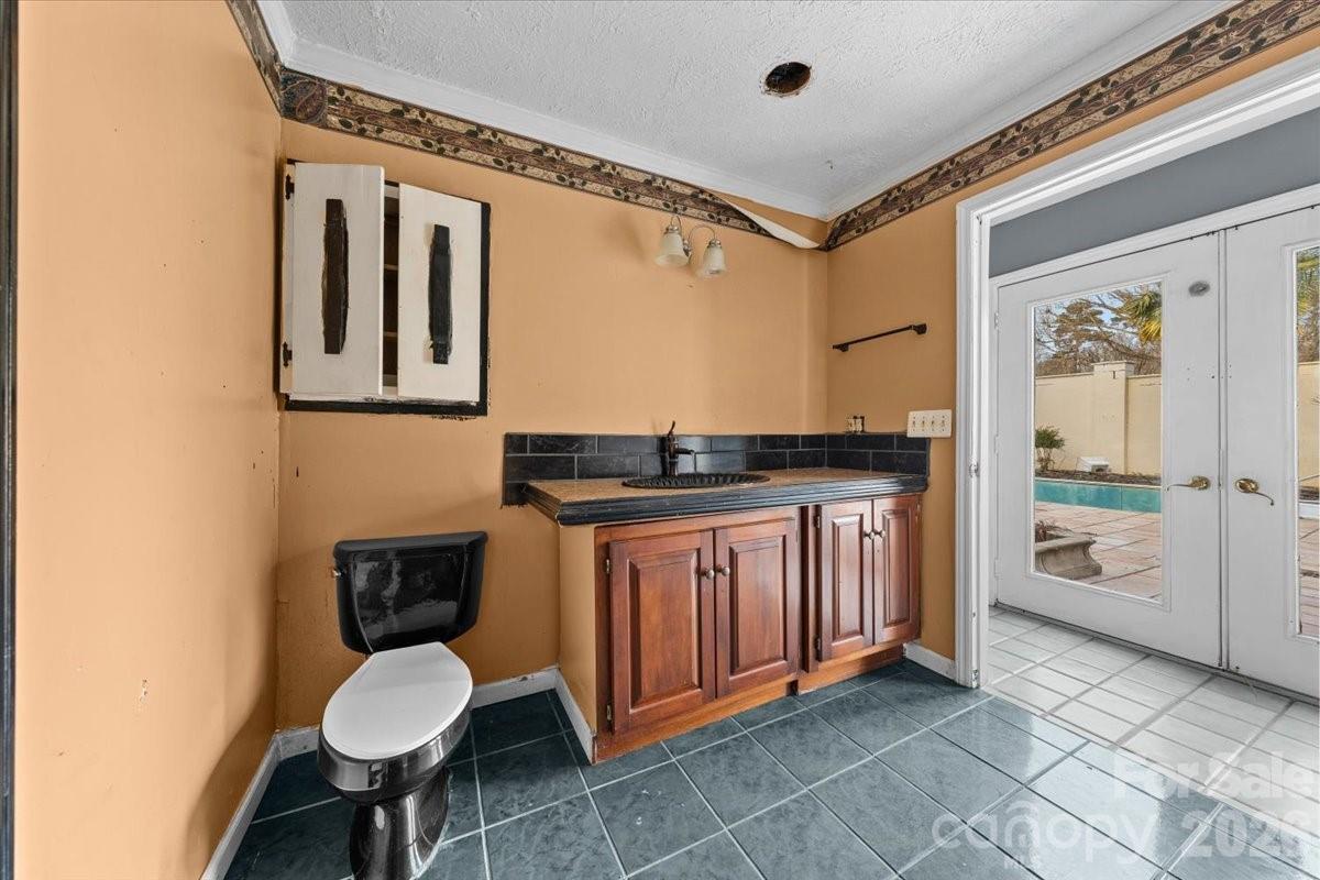 444 Craven Street Star, NC 27356 - Photo 34 of 48 a bathroom with a granite countertop sink a toilet and a mirror