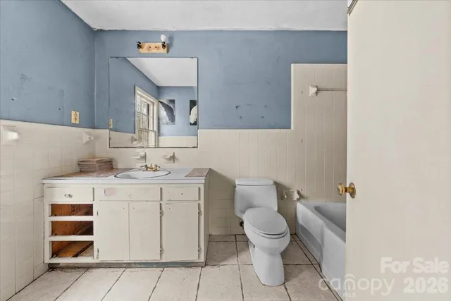 a bath room with a toilet a sink and a mirror
