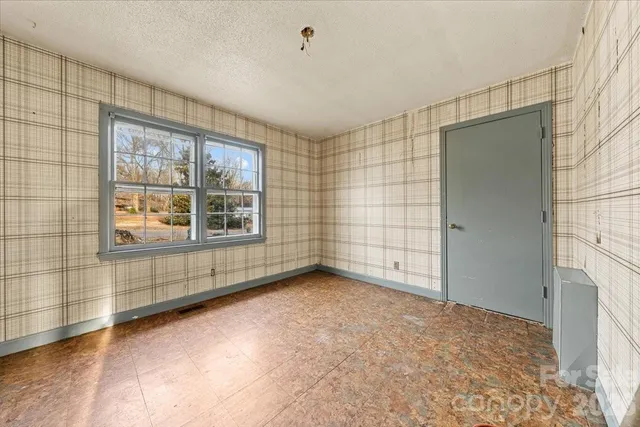 a view of a porch with a floor to ceiling window and wooden floor