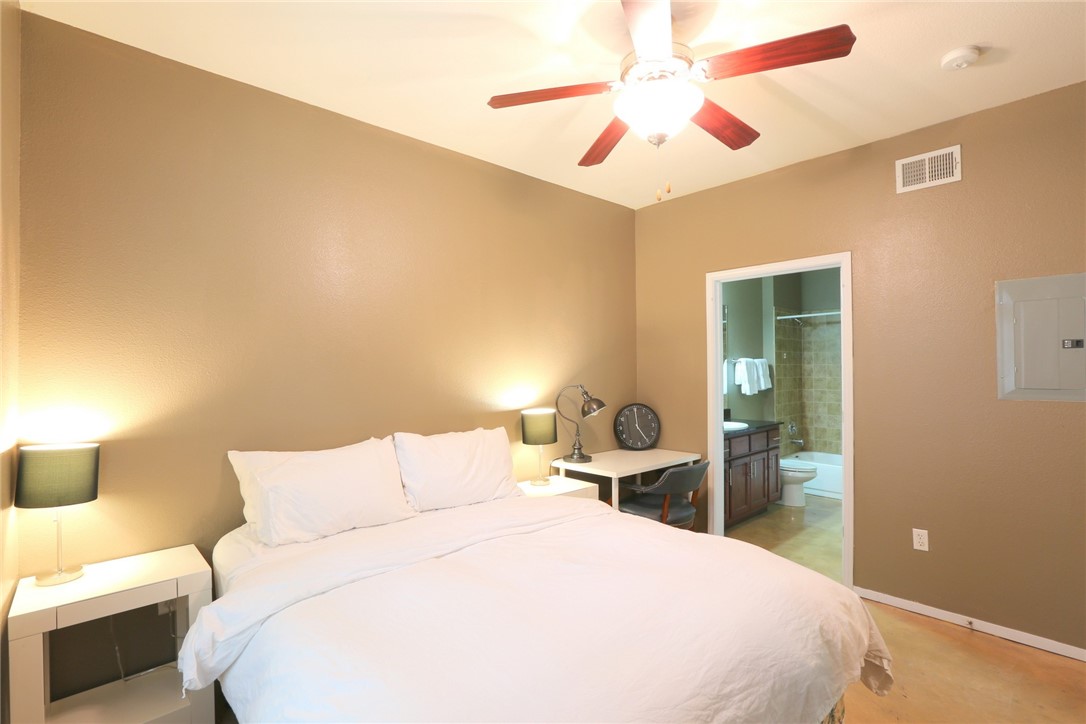 910 West 25th Street, Unit 502 Austin, TX 78705 - Photo 12 of 26 a bedroom with a bed and a chandelier