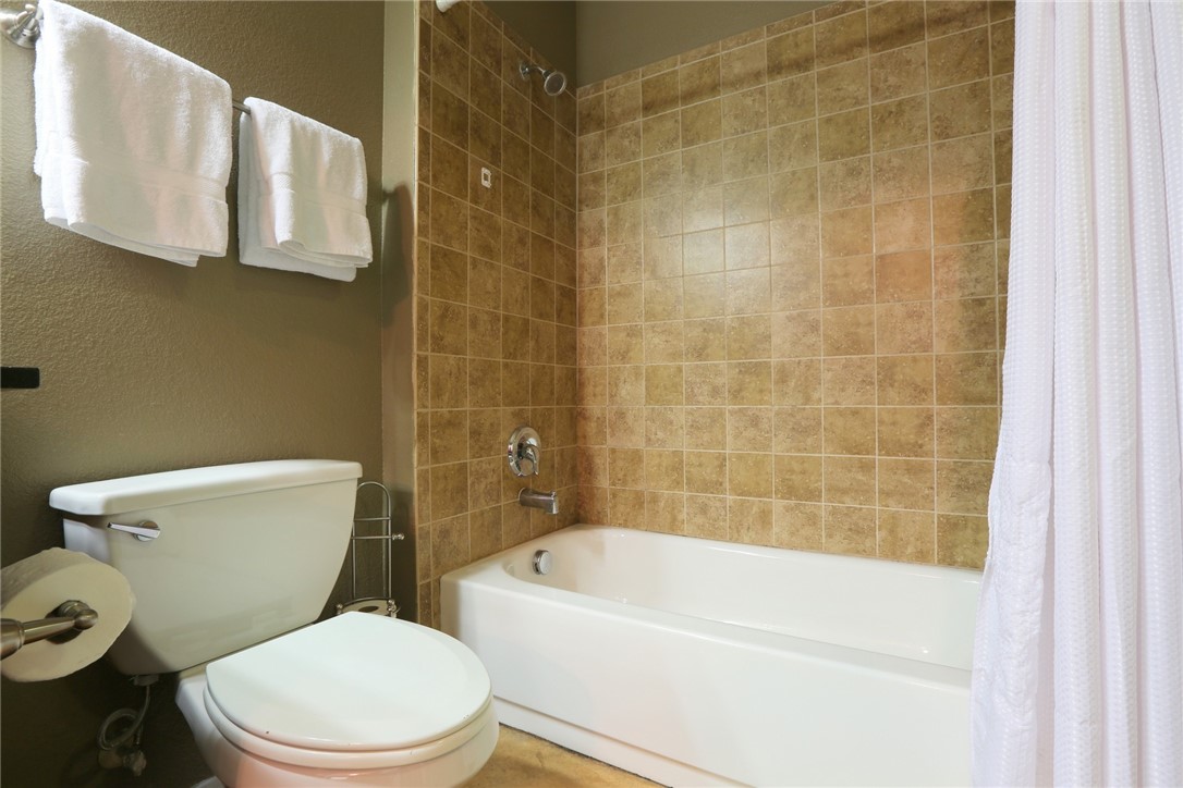 910 West 25th Street, Unit 502 Austin, TX 78705 - Photo 14 of 26 a white toilet sitting next to a bath tub