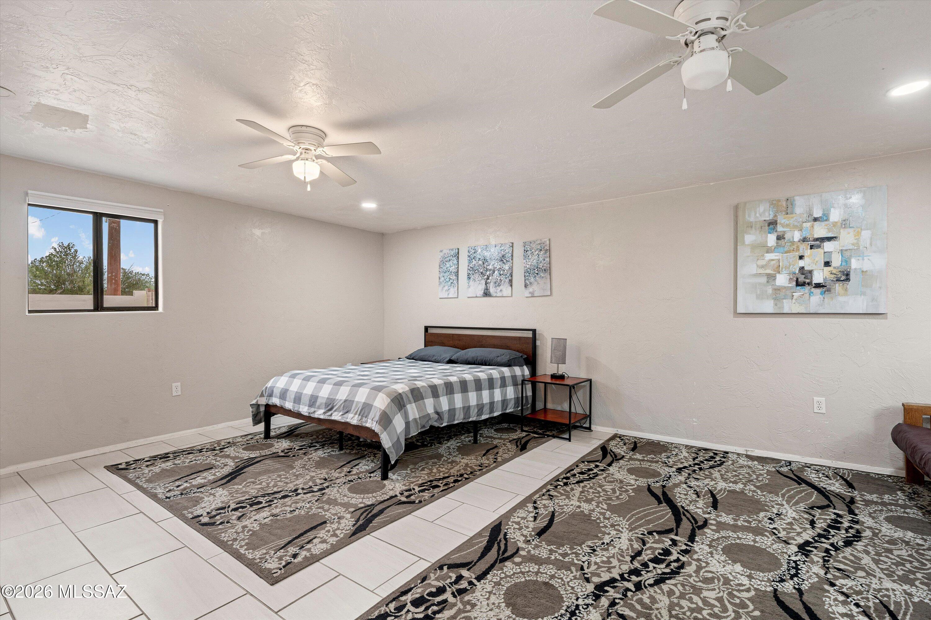 2841 North Richey Boulevard Tucson, AZ 85716 - Photo 15 of 30 a bedroom with a bed dresser and wooden floor