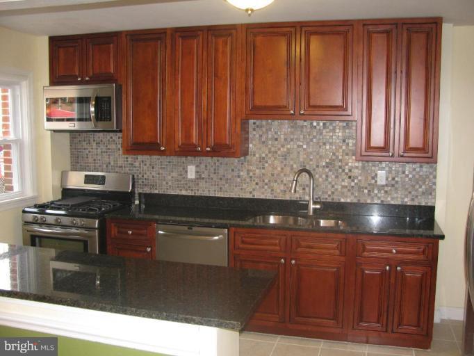 1614 Burnwood Road Baltimore, MD 21239 - Photo 6 of 11 a kitchen with stainless steel appliances granite countertop a stove a sink dishwasher and a microwave