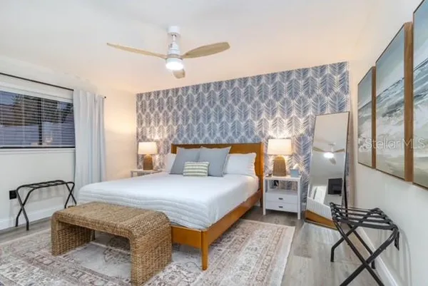 a bedroom with a bed wooden floor and window