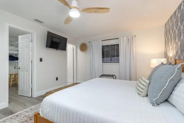 a spacious bedroom with a bed and a flat screen tv