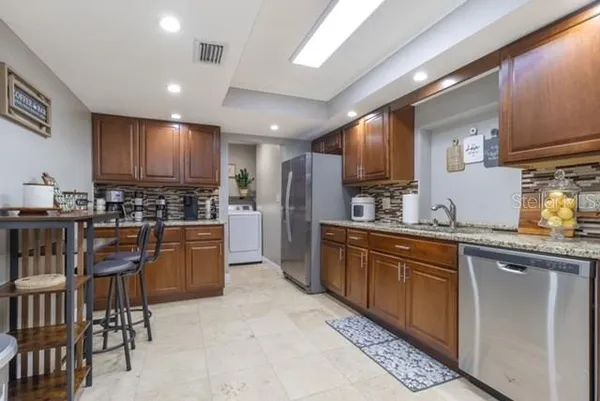 a kitchen with stainless steel appliances granite countertop a stove sink and cabinets