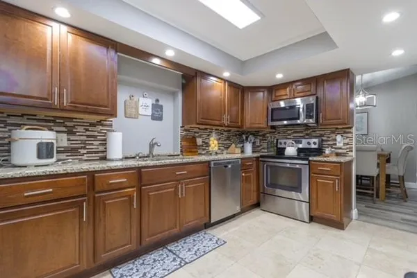 a kitchen with sink a stove and chairs