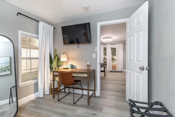 a view of a livingroom with wooden floor and furniture