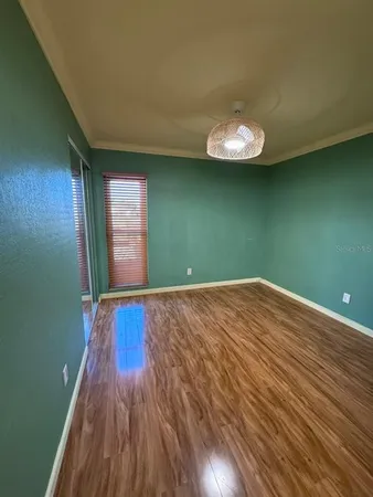 a view of empty room with wooden floor