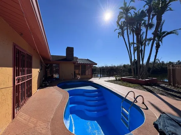 a view of a lake with a table and chairs under an umbrella