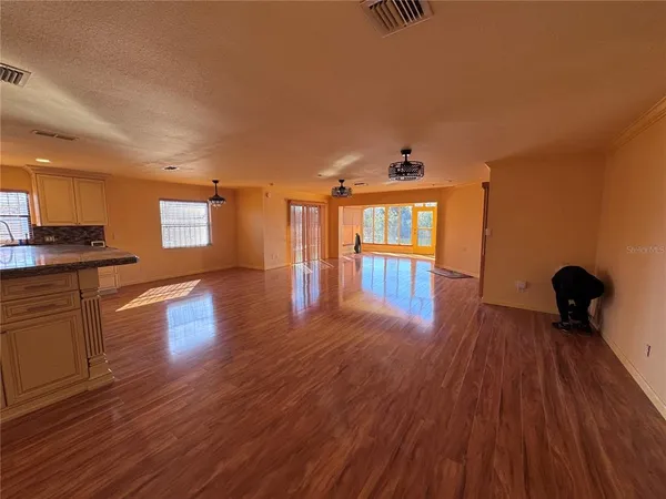 a view of a room with wooden floors and a ceiling fan