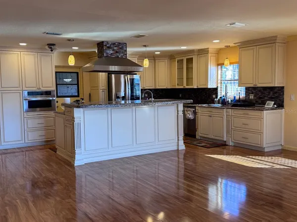 a living room with kitchen and a wooden floor