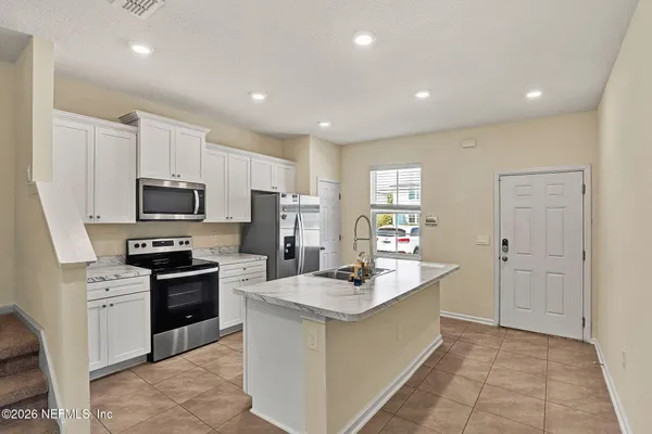 a kitchen with kitchen island a sink stainless steel appliances and cabinets