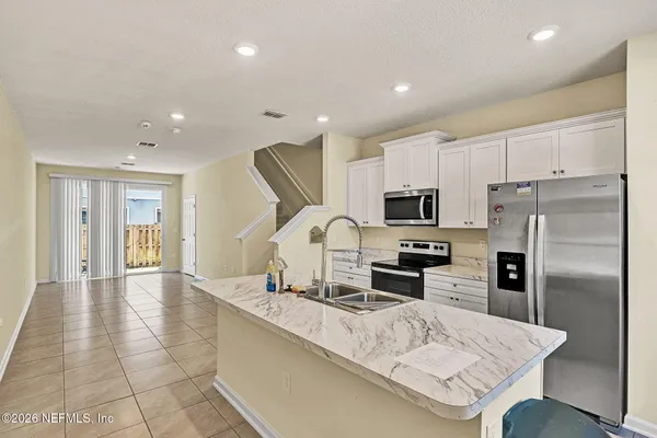 a kitchen with stainless steel appliances granite countertop a refrigerator and a sink